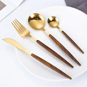 Gold stainless steel cutlery set with wood grain handle, including knife, fork and spoon.