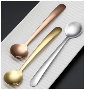 Close-up detail of mini stainless steel round spoons in gold, silver, and rose gold.