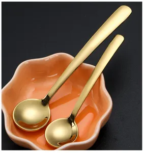 Stainless steel mini gold coffee spoons set with cute flower ceramic dish detail shot.