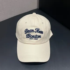 Classic beige baseball cap with blue embroidered lettering, soft top design, casual sun hat.
