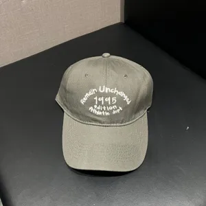 Close-up view of the gray baseball cap featuring stylish white letter embroidery on the front.