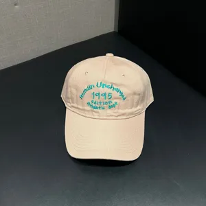 Detailed view of beige baseball cap with green embroidery, soft top curved brim hat for daily wear.