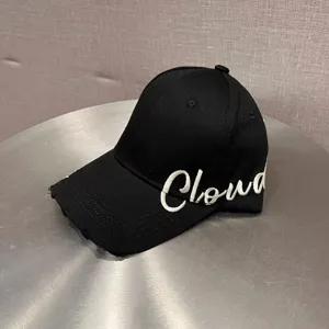 Close-up shot of a black hard-top baseball cap featuring white embroidered Cloud text.