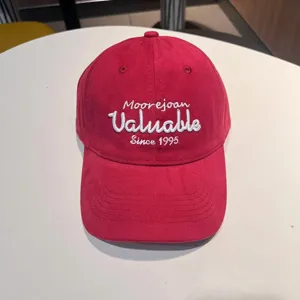 Close-up detail of the pink embroidered baseball cap showing the delicate front white stitching.