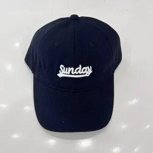 Vista di dettaglio ravvicinata del cappellino da baseball nero con ricamo bianco Sunday.