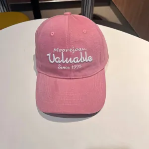 Pink washed cotton baseball cap with front embroidery letters, casual soft top sun hat detail.