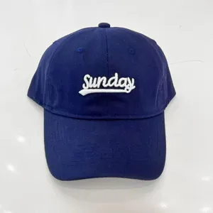 Primo piano di un berretto da baseball blu navy, ricamo Sunday bianco, stile casual.