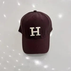 Vintage dark brown baseball cap featuring a stylish white embroidered letter H design.