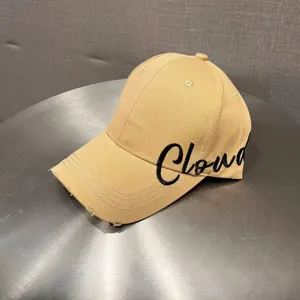 Distressed khaki baseball cap with black embroidered letter Cloud for stylish sun protection.