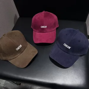 Close-up of casual suede baseball caps with embroidered letters, featuring three versatile colors.