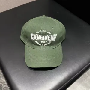 Detailed view of the army green structured baseball cap with stylish white embroidery text.