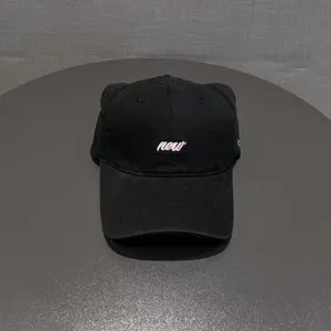 Detail view of a black cat ear baseball cap with front embroidery text, casual style.