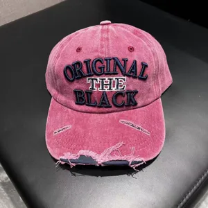 Closeup detail of vintage washed distressed denim baseball cap with front embroidery.