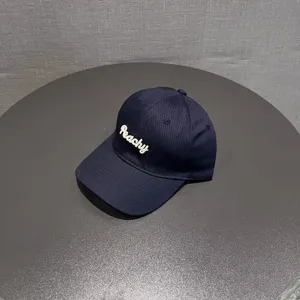 Detailed shot of a navy blue embroidered baseball cap with Peachy text for women casual wear.