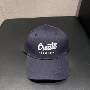 Close-up view of dark blue embroidered baseball cap featuring white Create text and detailed stitching.