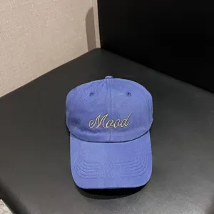 Detailed view of a blue cotton baseball cap featuring embroidered Mood text on the front.