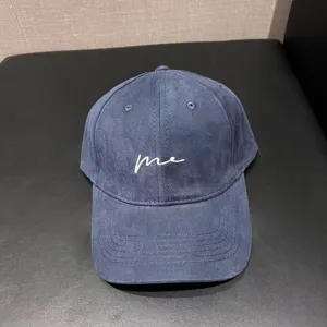 Casual dark blue baseball cap with white embroidered lettering me and curved brim.