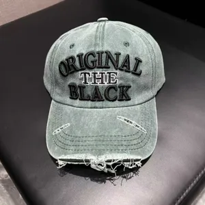 Close-up of distressed washed denim baseball cap featuring bold embroidered front lettering.