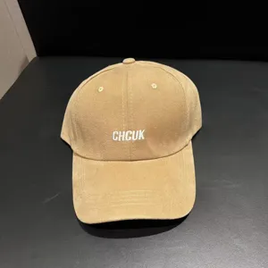 Close-up detail of the khaki brushed baseball cap with white embroidered text on front.