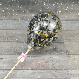 Clear confetti balloon cake topper detail with stick and pink bow for party decoration.