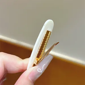 Primo piano dettagliato sul fermaglio per capelli ovale bianco, clip a becco d'anatra.