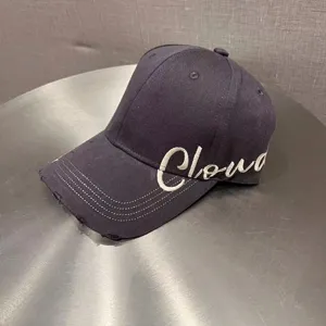 Black distressed baseball cap with white embroidered letter design for casual summer sun protection.