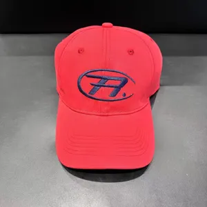 Red baseball cap embroidered logo detail, casual streetwear headwear, close-up shot.