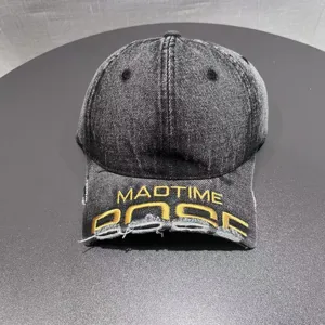Primo piano del cappellino da baseball in denim slavato con dettagli di ricamo giallo.