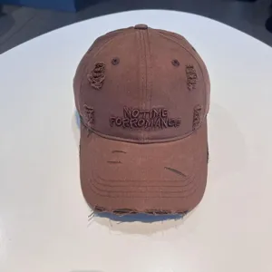 Vintage distressed brown baseball cap with front embroidery, casual streetwear style.