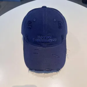 Distressed dark blue baseball cap with embroidered letters, vintage casual streetwear hat.