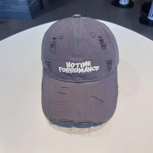 Grey distressed baseball hat front detail with white embroidered letters and ripped holes.