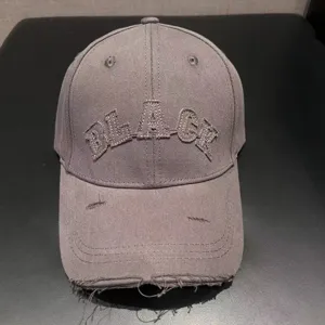 Detail view of the American retro distressed baseball cap in grey with front letter embroidery.