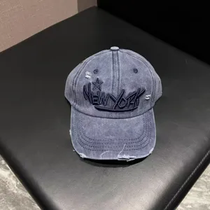 Detailed view of the vintage washed denim baseball cap with embroidered New York text and star.