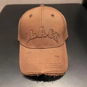 Distressed brown baseball cap with embroidered lettering for vintage street style look.