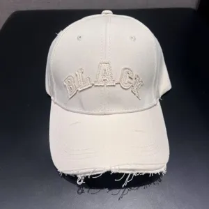 Retro washed baseball hat with distressed brim and embroidered letters for street style wear.