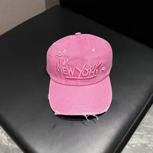 Close-up detail of the pink washed distressed baseball cap with embroidered lettering and star.