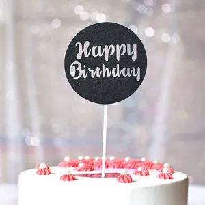 Gros plan détail du cake topper rond Happy Birthday avec paillettes noires sur gâteau décoré.