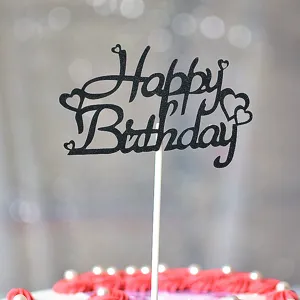 Gros plan de la cake topper Joyeux Anniversaire noire pailletée avec cœurs, fête.