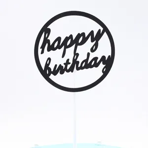 Close-up detail view of black round Happy Birthday cake topper with white stick on a cute cake.