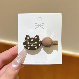Detailed close-up shot of the cute brown polka dot cat hair clip side duckbill hairpin accessory.
