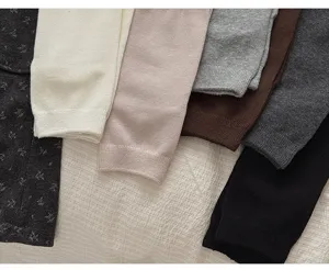 Close-up detail of cozy knit leg warmers in assorted autumn colors, soft texture.