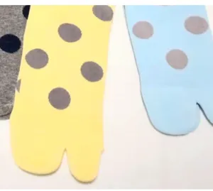 Detailed view of women's polka dot split toe mid tube socks in cute retro colorful styles.
