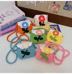 Closeup detail view of handmade crochet mini flower shoulder bag, cute wool knitted coin purse.