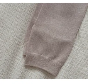 Close-up detail of soft cotton knitted leg warmers showing fine texture and fabric.