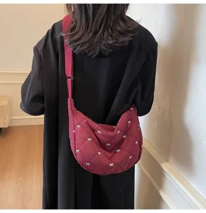 Detail view of the quilted casual dumpling shoulder bag featuring cute white bow patterns.