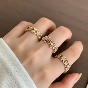 Détail de bague ajourée dorée avec strass, style vintage floral bijoux très élégants.