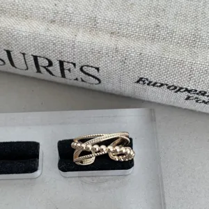 Gros plan d'un bague dorée à perles multicouches, détail de bijou vintage minimaliste.