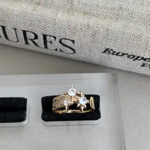 Gros plan detaille dune bague etoile zircon vintage, bijoux or multicouche fin.