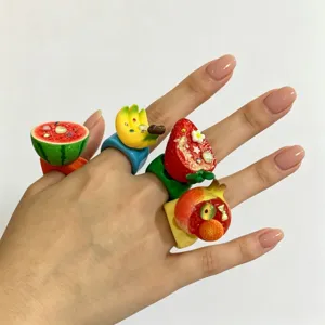Vue rapprochée des bagues en résine de fruits Y2K colorées pastèque, banane et fraise.
