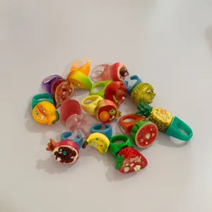 Gros plan détaillé sur des bagues de fruits en résine colorée aux motifs de divers fruits.